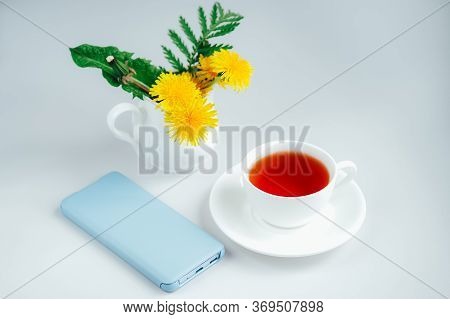 Morning Tea With Light Blue Mobile Phone, Bouquet Of Yellow Spring Dandelion Flowers. Beautifully St