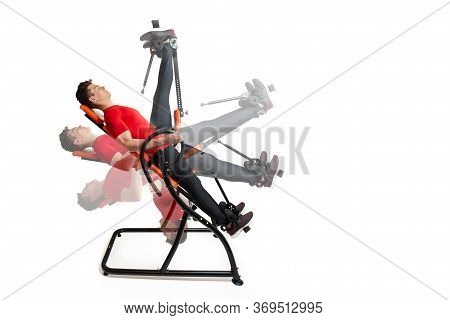 Man Doing Exercise On Inversion Table For His Back Pain, Isolated On White