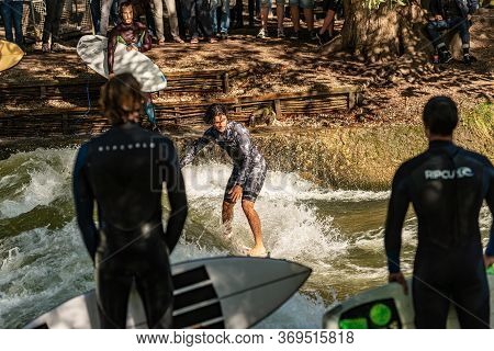 Munich, Germany - Sept 8, 2018: Man Surfing In The Waves Of The Eisbach River In Munich. It Forms A 