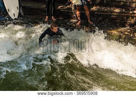 Munich, Germany - Sept 8, 2018: Man Surfing In The Waves Of The Eisbach River In Munich. It Forms A 