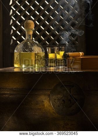 Close Up View Of Bottle Of Tequila Anejo And Cigar On Color Background