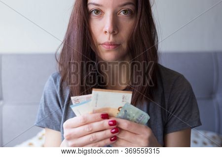 Young Sad Woman Holding Euro Money In Her Hands. Economy And Financial Crisis. Saved Money. Financia