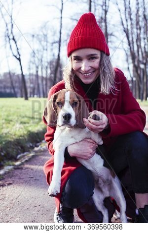Pretty Young Girl In Redd Coat Playing With Dog Outside In Green Park, Lifestyle People Concept