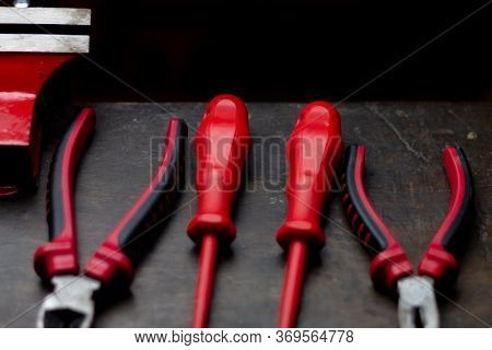 Red Tools On A Work Table On A Black Background