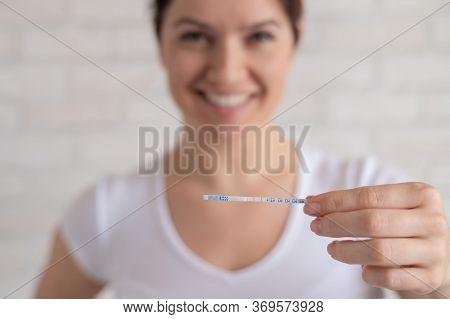 Happy Woman Shows A Positive Ovulation Test. The Concept Of Female Fertility And High Luteinizing Ho