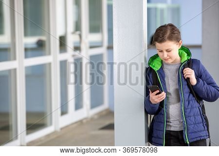 Truancy Concept, Young Boy Staying Away From The School And Playing Games On The Mobile, Absence Fro
