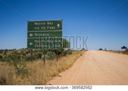 Solitaire, Namibia, November 2012: Namibian Gravel And Dirt Road With Directional Sign To Walvis Bay