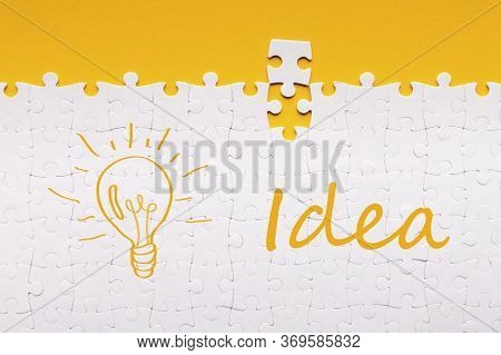 Great Idea. Last Detail For Assembled White Puzzle With Inscription And Lit Lamp On Yellow Backgroun