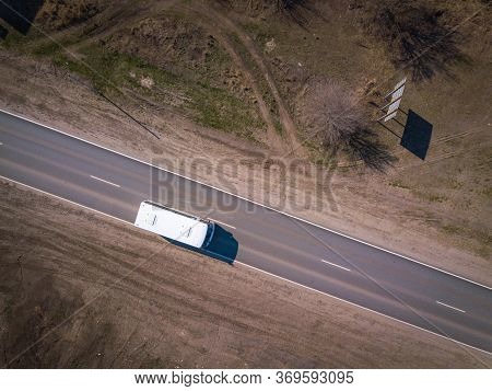 Aerial Of A School Bus On A Rural Highway. Aerial Top Down Shot.
