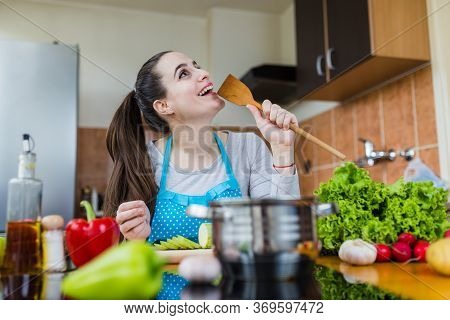 Happy Woman Singing In The Kitchen While Preparing Healthy Meal.