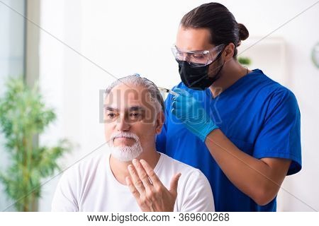 Old man visiting young male doctor in hair transplantation conce