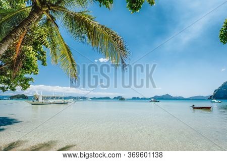 El Nido, Palawan Island, Philippines. Palm Trees Of Corong Corong Beach, Island Hopping Boats In Blu