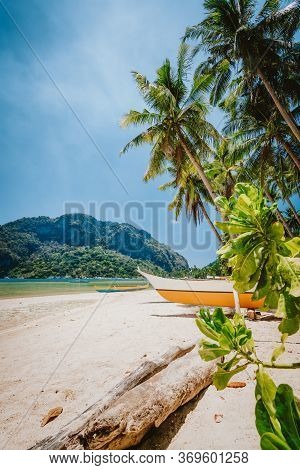 Philippines Beach Landscape - Local Banca Boat Under Palm Trees At Corong Corong Beach In El Nido, P