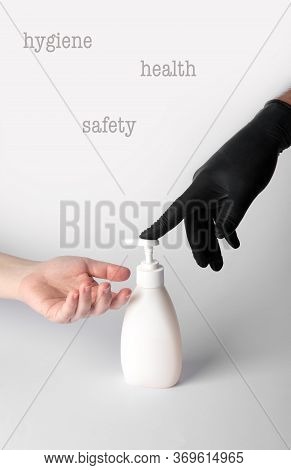 Someone Gives A Disinfectant Gel To The Hands Of Another Person