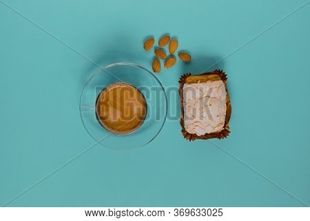 A Glass Cup Of Black Coffee With Merinque Cake And Almond. Top View.