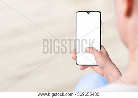Woman Sitting And Holding Blank Screen Mock Up Mobile Phone, Woman's Hand Holding Cell Phone With Bl