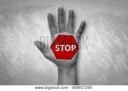 Hand Raised With Stop Sign Painted. Emotional Black And White Photo With Red Symbol.