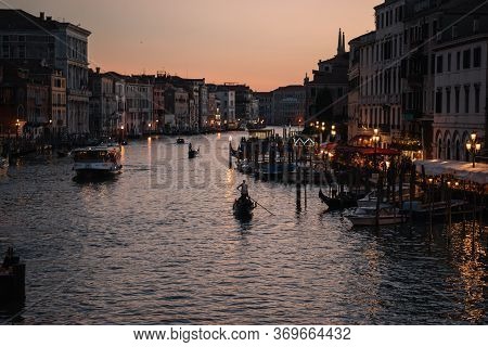 Gondoliers At Dusk On The Grand Canal Of Venice, Italy.