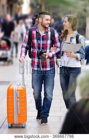 Happy Travelers With Baggage Heading To Hotel On Foot