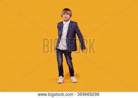 A Full-length Boy In A Shirt And Gray Jacket Dances A Fashionable Dance.