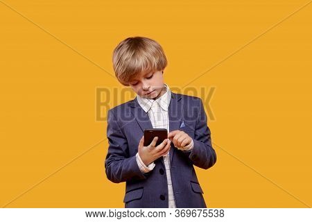 The Blonde Boy Uses A Black Mobile Phone.
