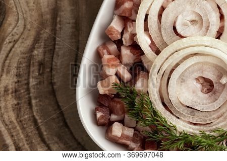Italian Pancetta, Bacon Cubes, Diced Ham, Cutted Pork, Sliced Onion In Square White Plate On Wooden 