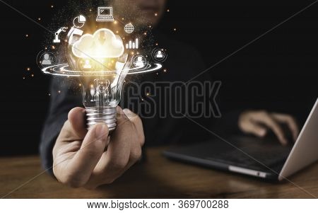 Hand Holding Lightbulb With Cloud Computing And Technology Icons Such As Laptop Computer Graph.cloud