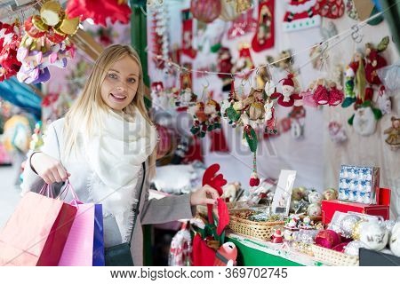 Cheerful Young Girl Shopping At Festive Fair Before Xmas At Christmas Market