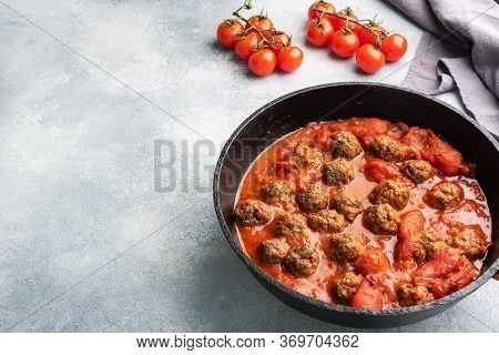 Delicious Juicy Meatballs In Tomato Sauce Are Cooked In A Castiron Pan. Concrete Background. Copy Sp