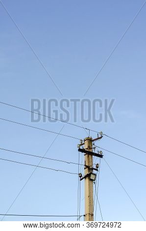Pillar With Wires Against The Sky. Concrete Pole With Lots Of Wires And Led Spotlights. Industry, El