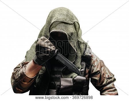 Isolated photo of a fully equipped camouflaged soldier in tectical net scarf with tactical vest and gloves holding knife reverse grip.