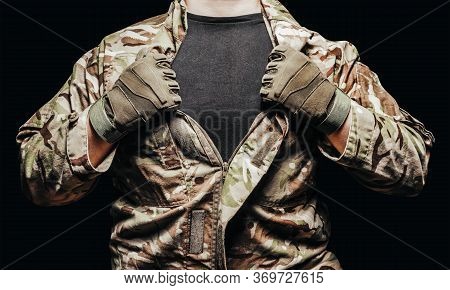 Photo of a soldier in multicam camouflage tunic on black background.