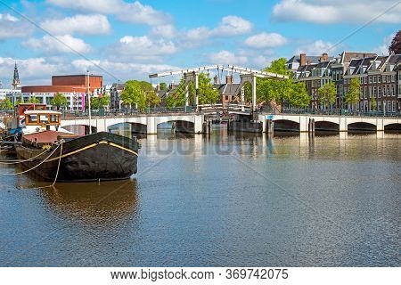 City scenic from Amsterdam at the river Amstel in the Netherlands with the Tiny Bridge
