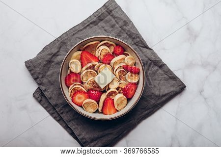 Trendy Home Breakfast With Tiny Cereal Pancakes With Piece Of Butter And Fresh Strawberries In The B