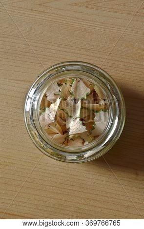 Shavings From A Green Ans White Pencil Contained In A Glass Jar.