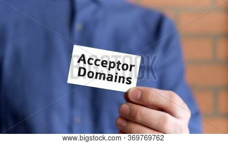 A Man In A Blue Shirt Holds A Sign With The Text Of Acceptor Domain In One Hand