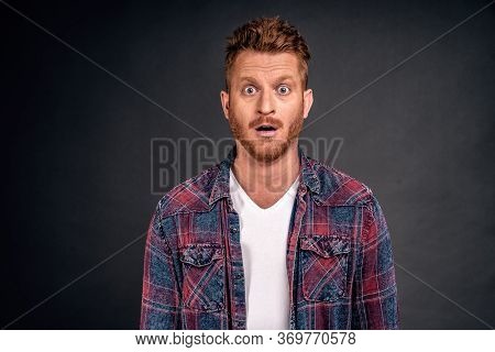 Redhead Male With Bristle Dropping Jaw As Seeing Incredible And Amazing Scenery, Posing Over Gray Ba