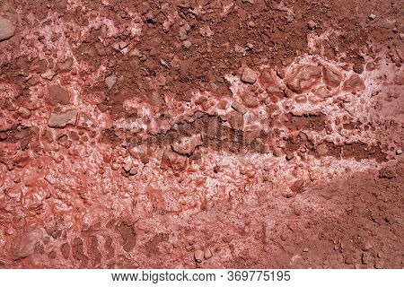 Red Cracked Soil Natural Background. Dried Earth In The Puddle.