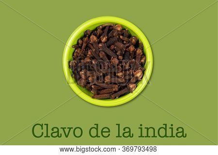 Green Bowl With Culinary Ingredients Clavo De La India  (text In Spanish) On Dark Green Background