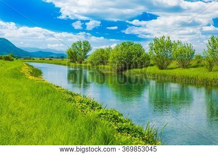 Croatian Landscape, River Gacka Flowing Between The Meadow Fields In Lika Region Of Croatia
