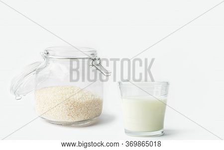 Glass Of Non-diary Animal-free Plant Based Milk Dry Rice In Crystal Jar On Shite Kitchen Table. Heal