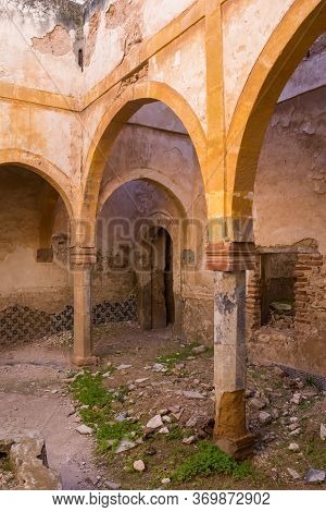 One Of Many Yards In An Abandoned House. Arcade With Arcs On A Columns.  Grass And Growing In The Ru