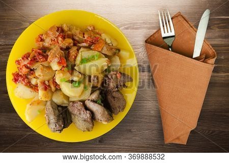Fried Liver With Potatoes And Stewed Tomatoes With Fork And Knige. Fried Liver On Yellow Plate On Br