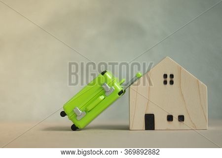 Miniature Green Suitcase With Miniature Wooden House.
Concept Of Vacation Rentals, Renting Private H