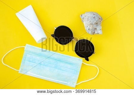 Unmarked White Tube, Cockleshell, Glasses And Medical Mask On A Yellow Background. Concept Of Skin C