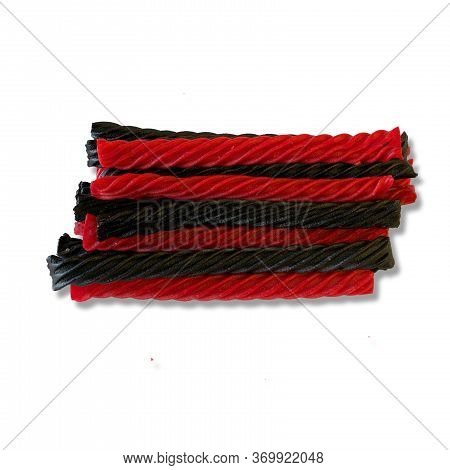 A Bunch Of Red And Black Liquorice Candy Bars On White Background