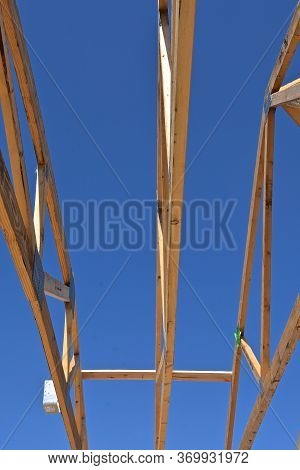 Pre-built Rafters Are Outlined Against The Blue Sky