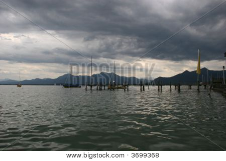 เมฆฝนมืดและ Chiemsee เลค (เยอรมนี) กับเทือกเขาแอลป์บาวาเรีย