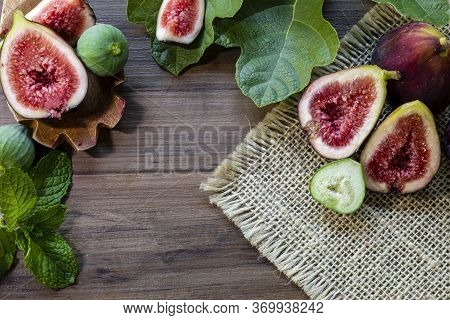 Figs, Green Leaves On Rustic Wooden Background