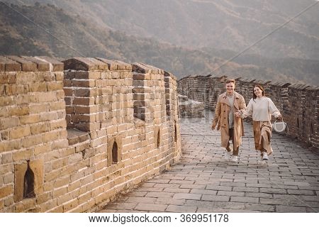 Young Couple Running And Twirling At The Great Wall Of China